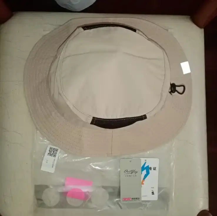 Chapeau seau beige avec étiquettes.