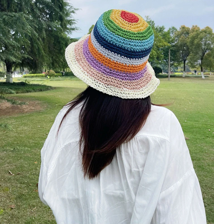 Femme portant un bob crochet en paille coloré avec des rayures de toutes les couleurs 